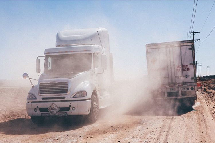 Trucks travelling through dirt road in Baja - Photo by Erin Feinblatt